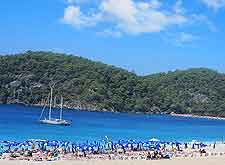 Beachfront view, showing sunbathers and yacht