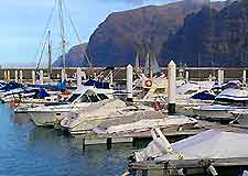 View of boats in a Tenerife marina with a backdrop of the Cliffs of the Giants